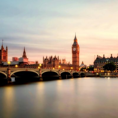 Scenic view of Big Ben and Westminster Bridge over the Thames River at sunset in London, UK.